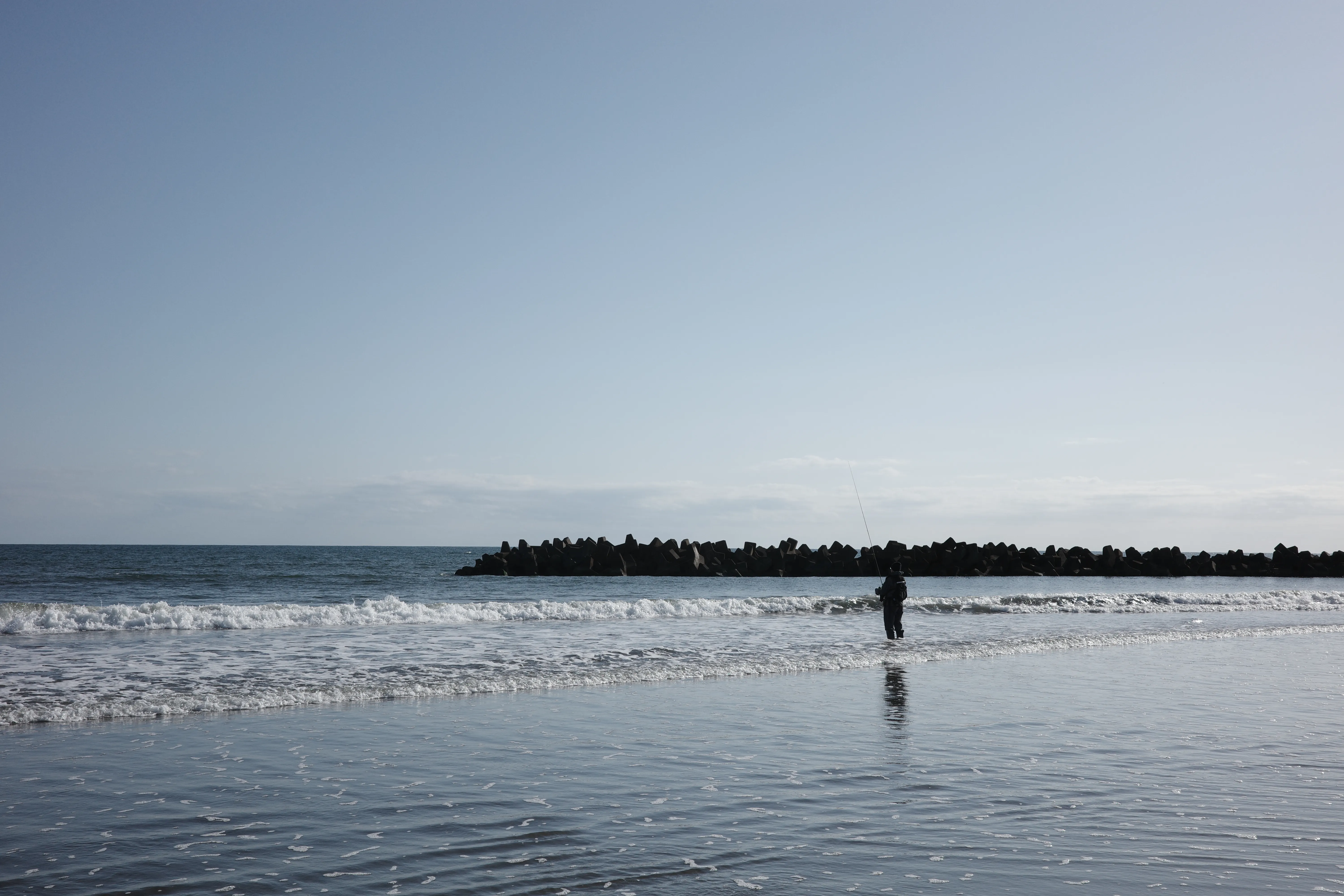 写真：浜辺で釣りに興じる人