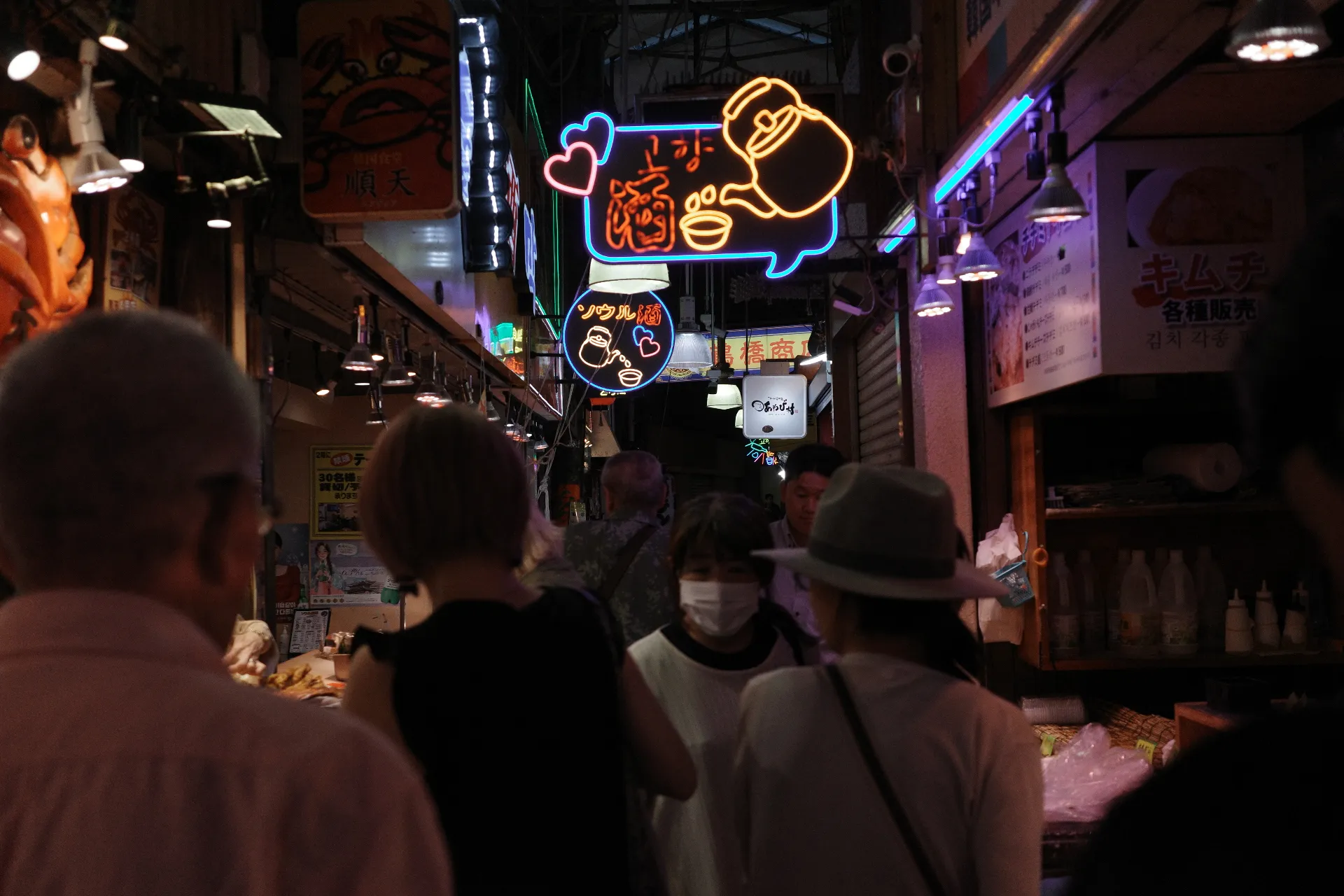 写真：鶴橋商店街の風景。特徴的なカラフルなネオンサインが見える。