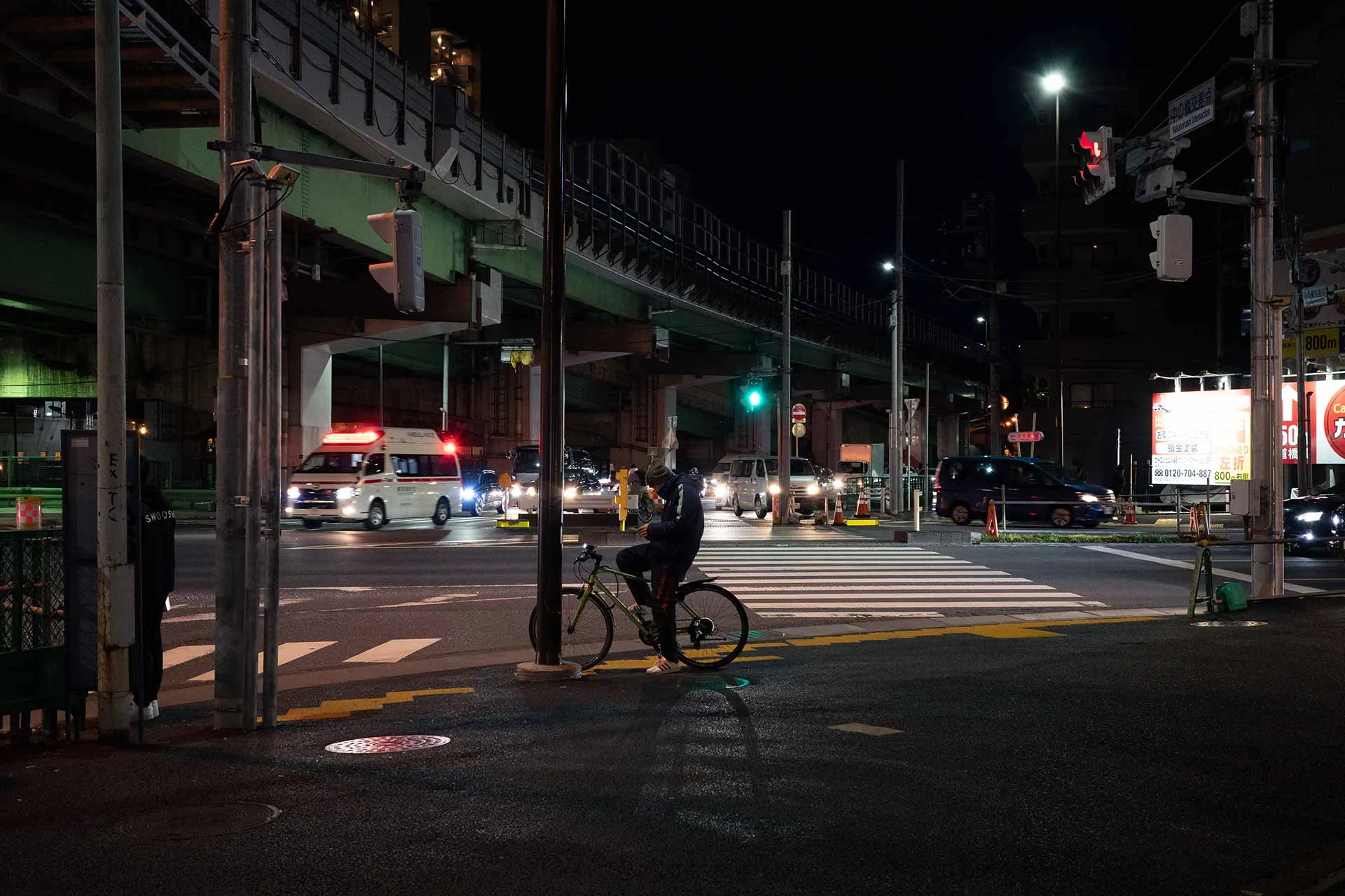 自転車で信号待ちする青年